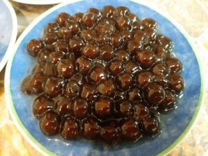 Perles et grains de tapioca dans un bol en céramique posé sur une table