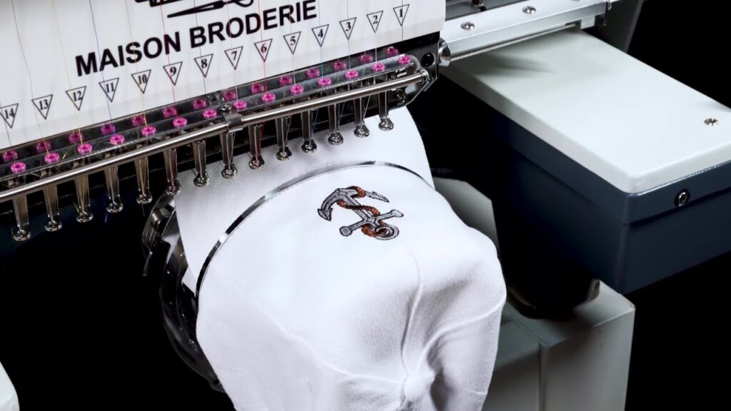 Casquette en coton en cours de broderie à la main avec un motif de fleurs colorées